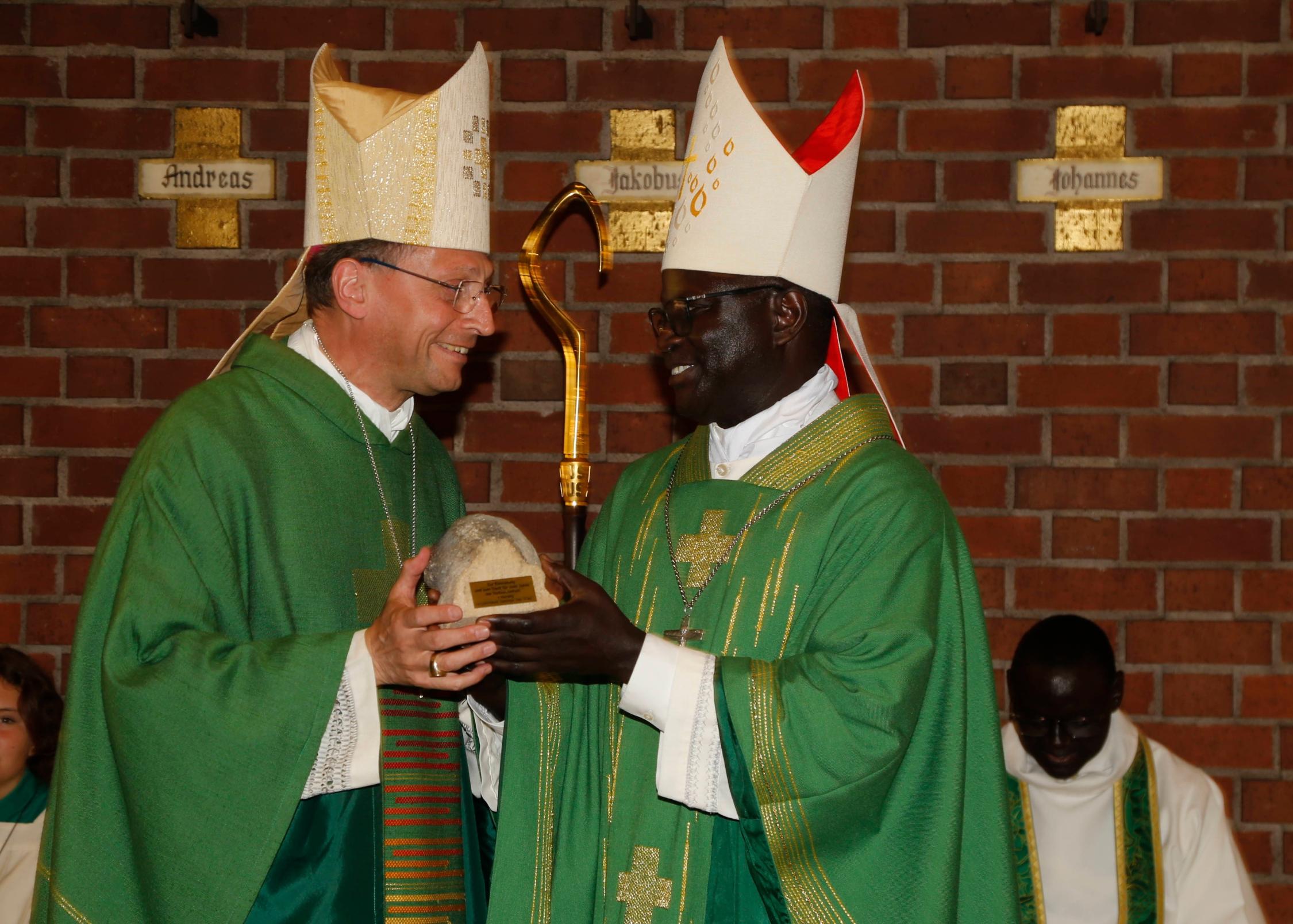 Ein Originalstein vom Bamberger Dom als Abschiedsgeschenk für Bischof André Guèye