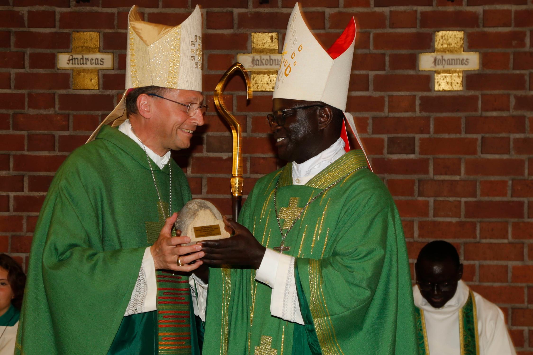 Ein Originalstein vom Bamberger Dom als Abschiedsgeschenk für Bischof André Guèye