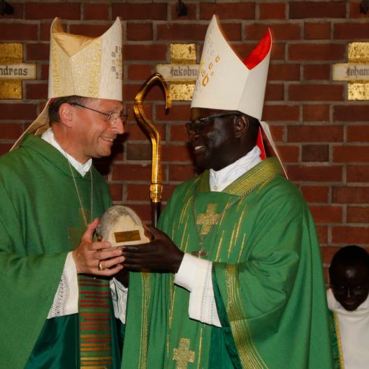 Ein Originalstein vom Bamberger Dom als Abschiedsgeschenk für Bischof André Guèye